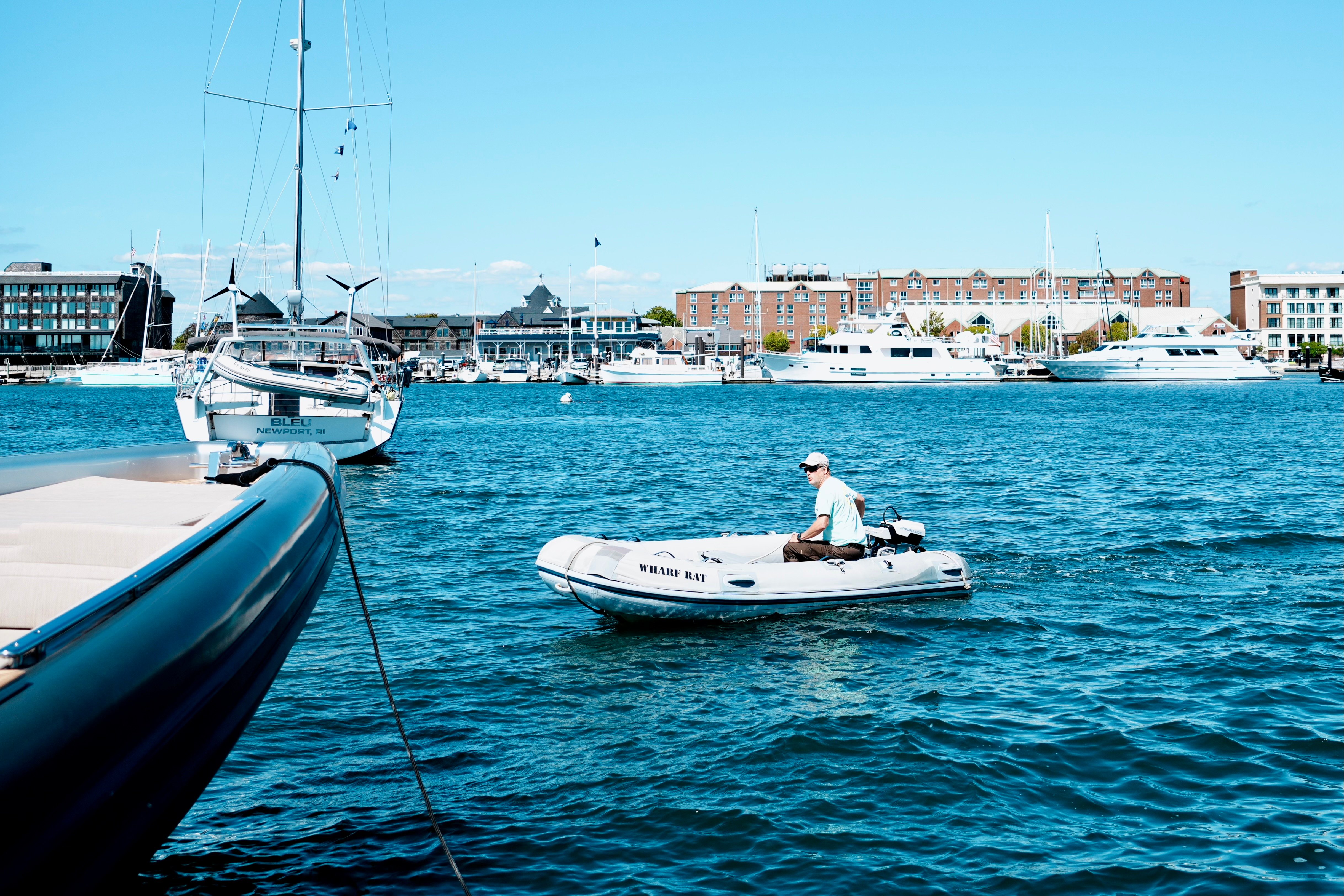 A man steering a boat in New Port Harbor.